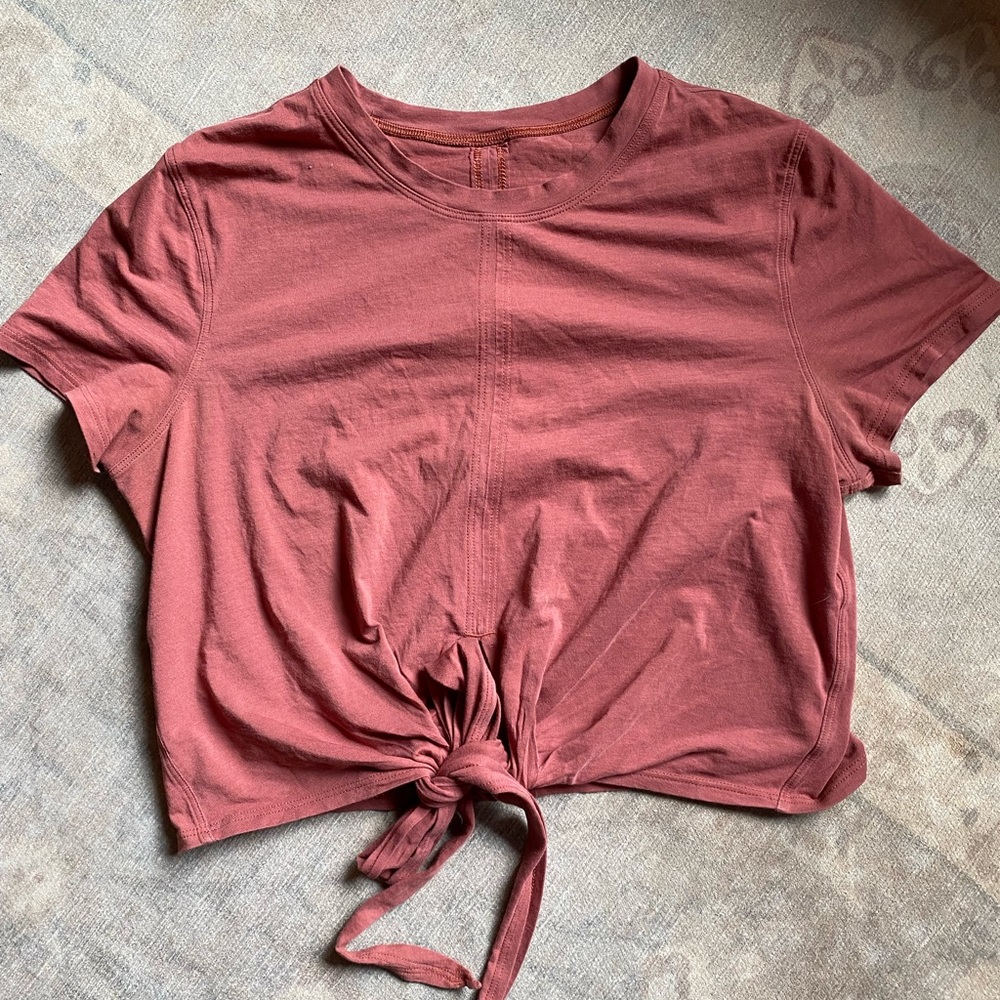 Lululemon. Burnt red color, great quality. Can tie the strings in front or back